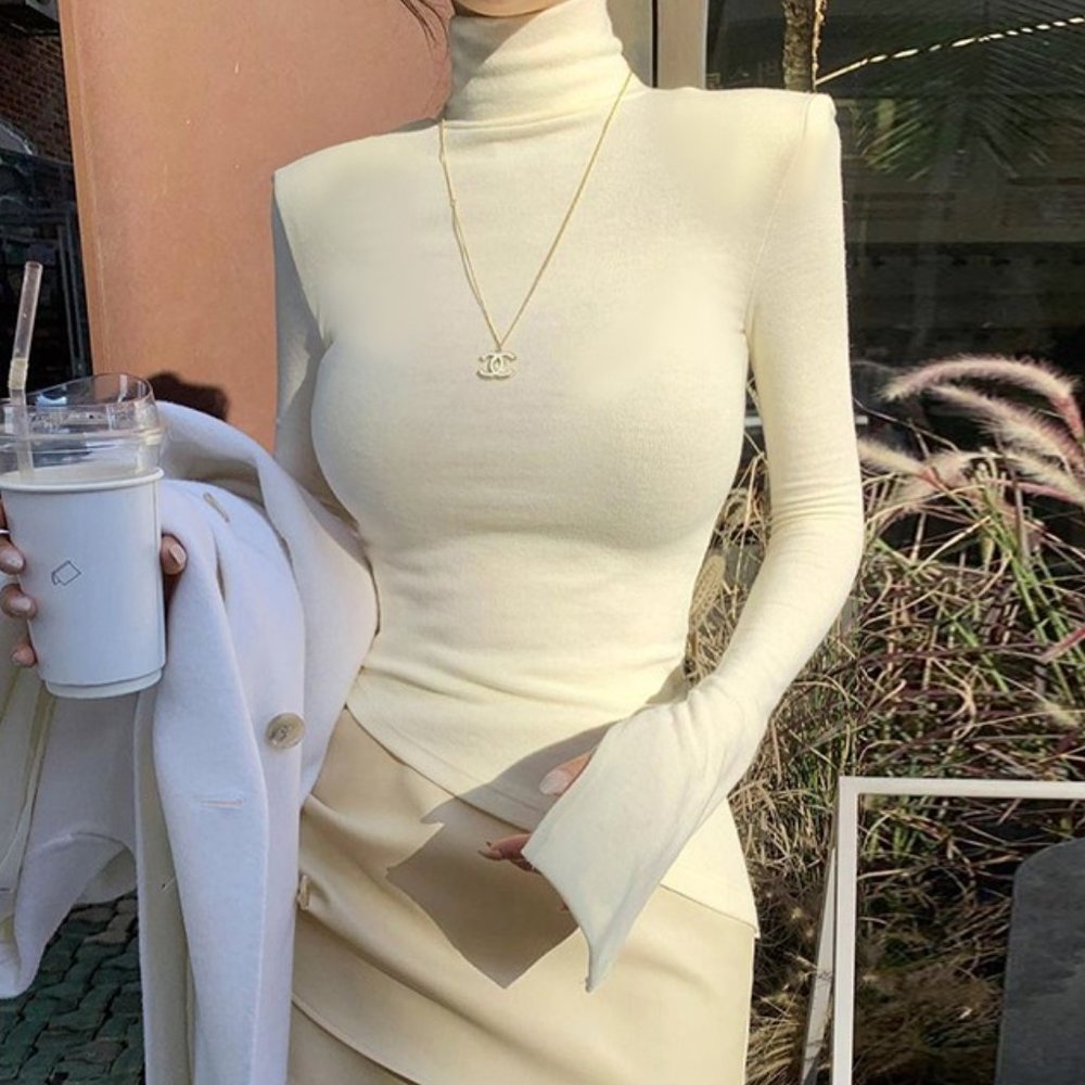 New High collar shoulder padded slant hem top